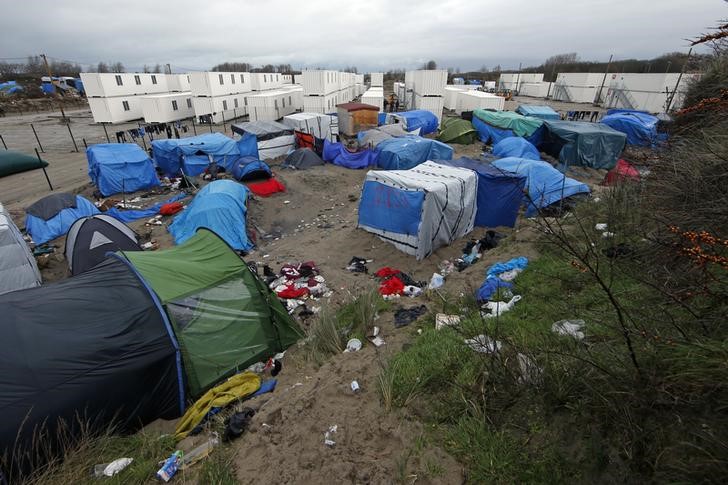 © Reuters. مهاجرون يواجهون شتاء قارسا في مخيم قرب كاليه بفرنسا