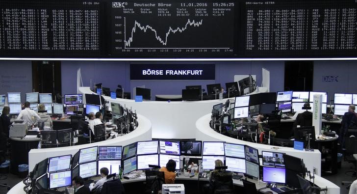 © Reuters. Traders work at their desks in front of the German share price index, DAX board, at the stock exchange in Frankfurt