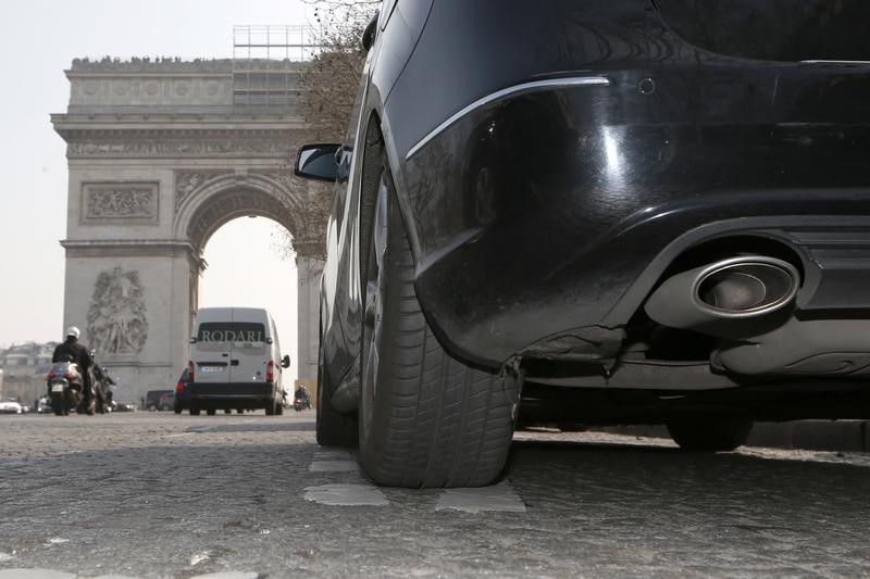 © Reuters. A car drives near the Arc de Triomphe in Paris during unusually high levels of pollution in France