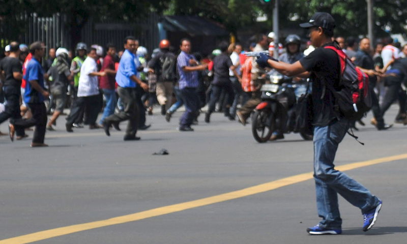 © Reuters. Man is seen holding a gun towards the crowd in central Jakarta