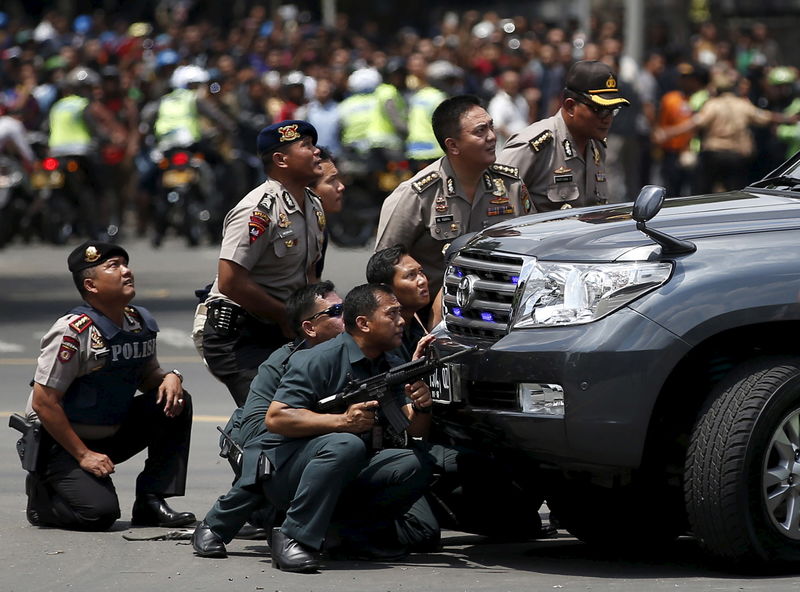 © Reuters. Police officers react near the site of a blast in Jakarta 