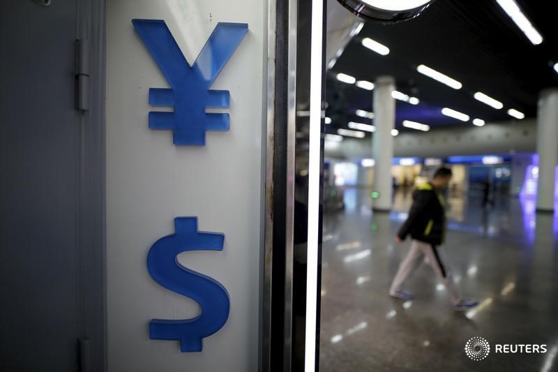 © Reuters. Signs of Chinese Yuan and U.S. dollar are seen at a foreign exchange store in Shanghai