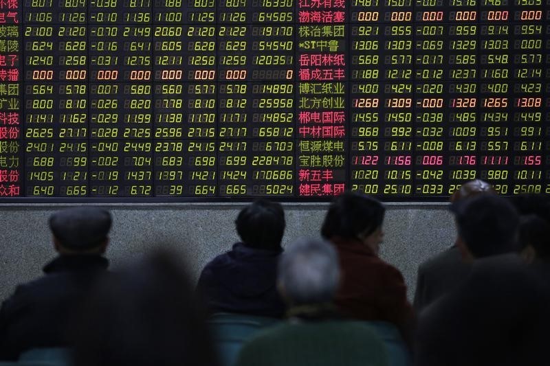 © Reuters. Investors look at an electronic board showing stock information at a brokerage house in Shanghai