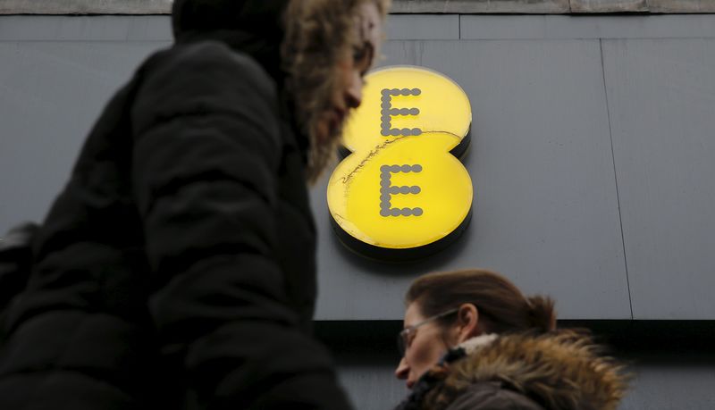 © Reuters. File photo of pedestrians walking past an EE shop in London