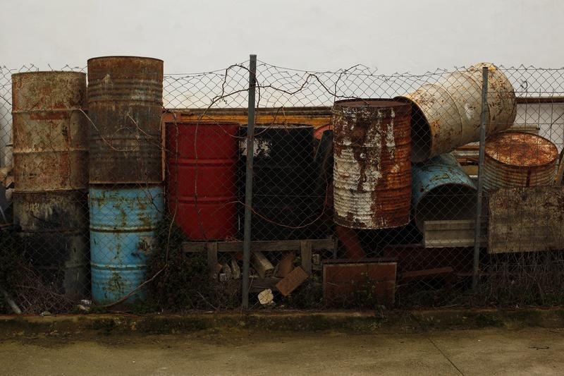 © Reuters. Rusted oil barrels, which are used as water tanks during the construction of buildings, are seen piled in a street in Cuevas del Becerro