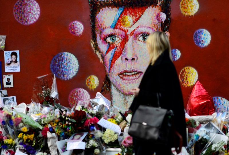 © Reuters. A woman looks as a mural depicting David Bowie in Brixton, south London