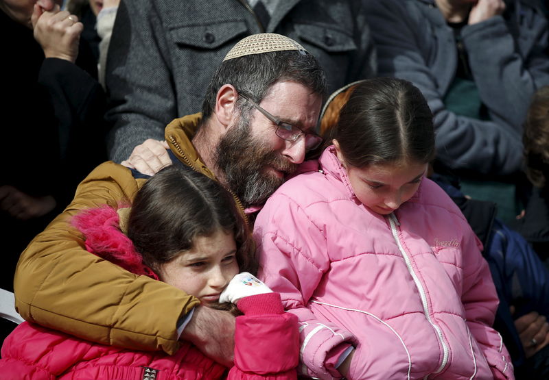 © Reuters. The husband and daughters of Meir mourn during her funeral at a cemetery in Jerusalem 