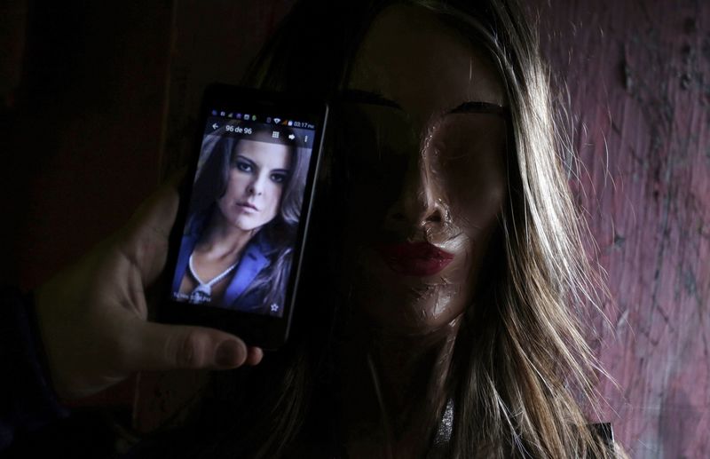 © Reuters. An artisan checks a photo of Mexican actress Kate del Castillo on his mobile phone to make a pinata depicting her at his workshop in Reynosa