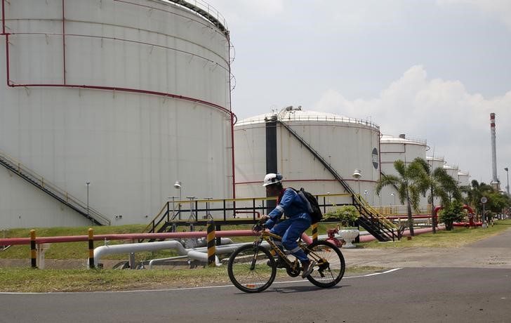 © Reuters. Велосипедист у НПЗ компании Pertamina на Яве 