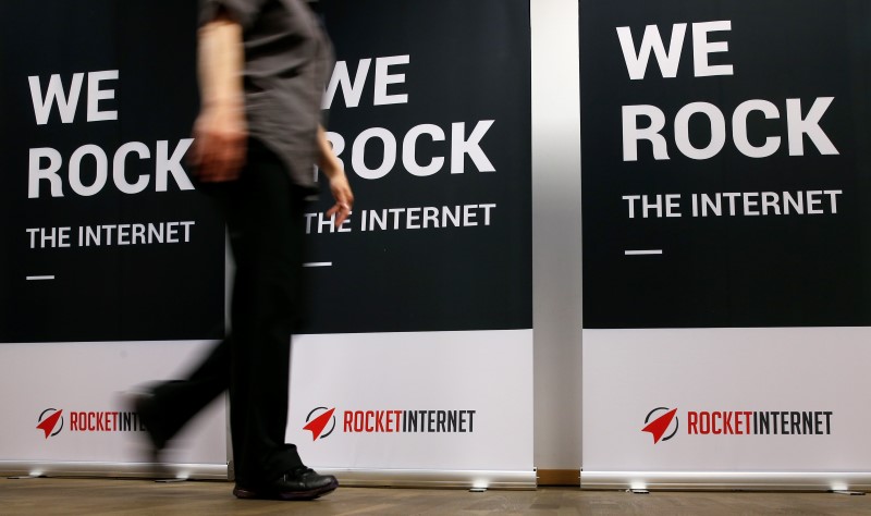 © Reuters. Женщина проходит мимо плакатов с логотипом Rocket Internet в Берлине