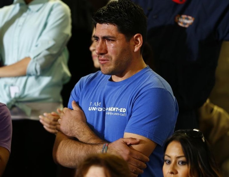 © Reuters. Patino of Phoenix, Arizona stands in the crowd after interrupting U.S. President Obama's speech that his new immigration policy would not help his immigration situation, at Del Sol High School in Las Vegas