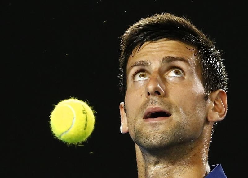 © Reuters. Serbia's Djokovic bounces a ball as he prepares to serve during his second round match against France's Halys at the Australian Open tennis tournament at Melbourne Park