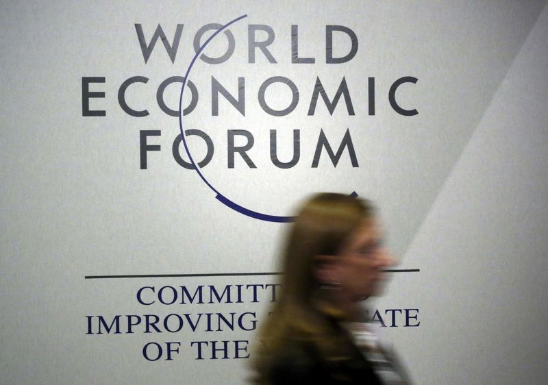 © Reuters. A person passes by a logo of the World Economic Forum during the annual meeting in Davos