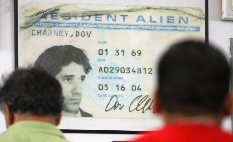 © Reuters. File photo of workers queuing for lunch in front of a poster-size photo of the first alien resident card of former company Chief Executive Dov Charney at the American Apparel factory in downtown Los Angeles