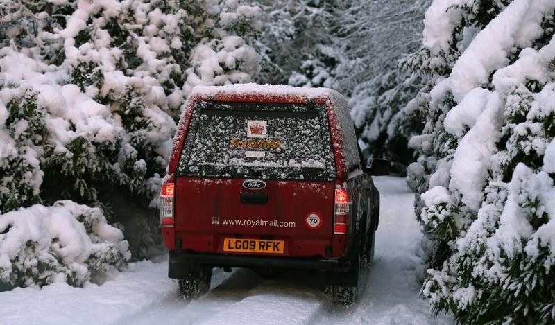 © Reuters. A Royal Mail delivery van drives through snow in Pitlochry