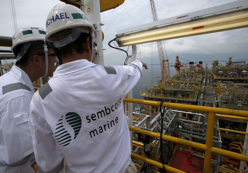 © Reuters. Sembcorp employees look at the modules on the main deck of Tullow Oil's newly completed Floating Production, Storage and Offloading vessel (FPSO) Prof. John Evans Atta Mills at Sembcorp Marine's Jurong Shipyard in Singapore