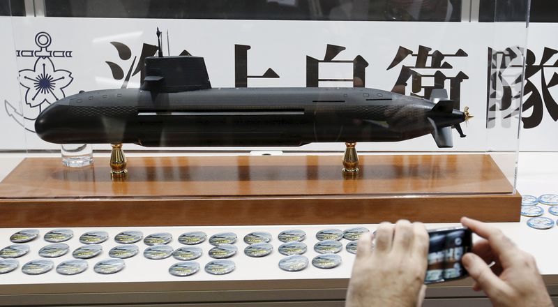 © Reuters. File photo of a visitor taking a picture of a model of Japan Maritime Self-Defense Forces diesel-electric submarine Soryu in Yokohama