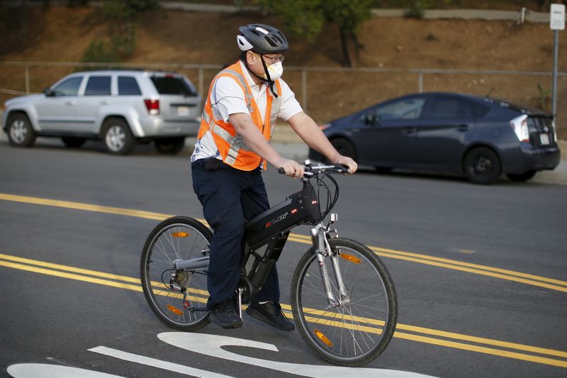 © Reuters. A man cycles wearing a face mask near the site of the Aliso Canyon storage field where gas has been leaking in Porter Ranch