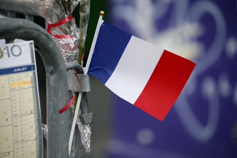 © Reuters. Una bandierina francese di fronte al teatro Bataclan a Parigi 