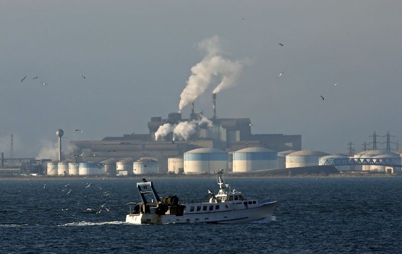 © Reuters. Рыбацкая лодка проходит недалеко от НПЗ компании DPF и металлургического комбината ArcelorMittal в Фос-сюр-Мер 