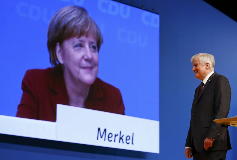 © Reuters. German Chancellor and leader of the CDU Merkel is seen on a video screen as Bavarian Prime Minister and head of the CSU Seehofer makes a speech at the CDU party congress in Karlsruhe, file