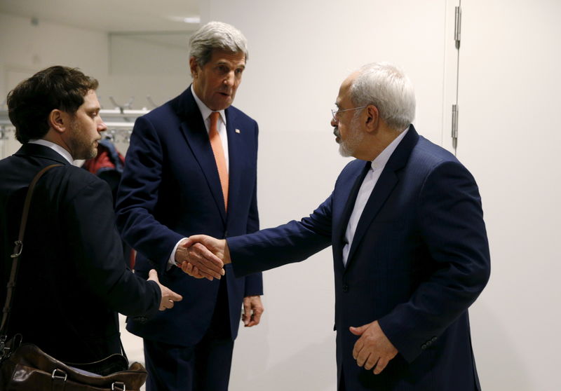 © Reuters. U.S. Secretary of State John Kerry shakes hands with Iranian Foreign Minister Mohammad Javad Zarif after the IAEA verified that Iran has met all conditions under the nuclear deal, in Vienna