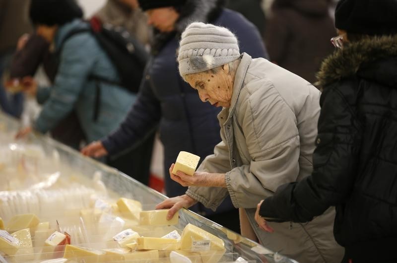 © Reuters. A woman chooses cheese at a hypermarket of French grocery retailer Auchan in Moscow