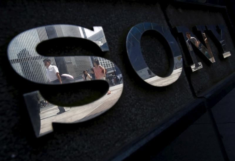 © Reuters. Pedestrians are reflected in a logo of Sony Corp outside its showroom in Tokyo