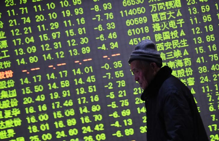 © Reuters. An investor walks past an electronic screen showing stock information at a brokerage house in Hangzhou