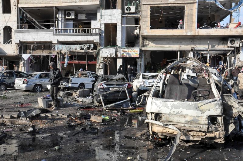 © Reuters. People inspect the site of a double bomb attack in the government-controlled city of Homs