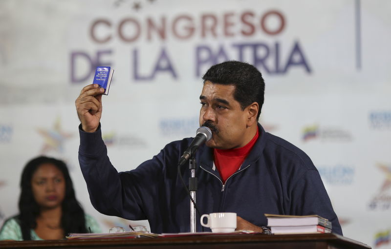 © Reuters. Venezuela's President Nicolas Maduro holds a copy of the country's constitution while he talks to supporters during an event at the 4F military fort in Caracas
