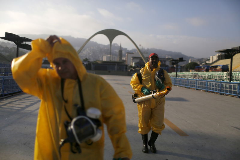 © Reuters. Municipal workers walk after spraying insecticide at Sambodrome in Rio de Janeiro