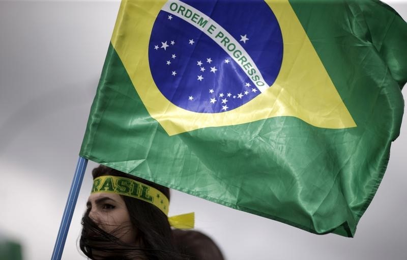 © Reuters. A demonstrator carries a Brazilian national flag during a protest calling for the impeachment of Brazil's President Dilma Rousseff near the National Congress in Brasilia