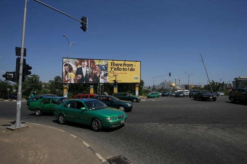 © Reuters. Vehicles stop at a traffic point by an MTN billboard in central business district Abuja, Nigeria