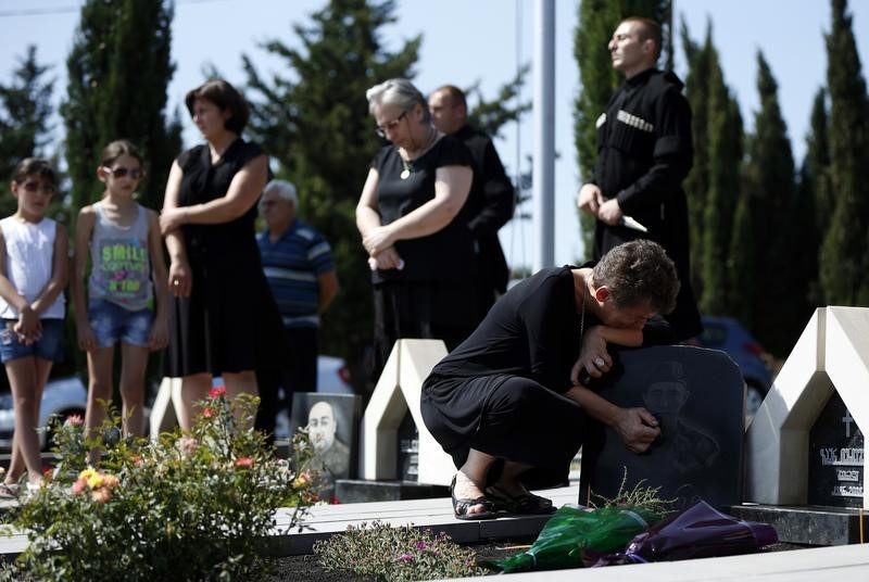 © Reuters. Relatives of the Georgian soldiers killed during Georgia's war conflict with Russia over the breakaway region of South Ossetia in 2008 l mourn at the memorial cemetery in Tbilisi
