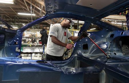 © Reuters. A Ford Motor assembly worker works on the frame of a 2015 Ford Mustang vehicle at the Ford Motor Flat Rock Assembly Plant in Flat Rock, Michigan