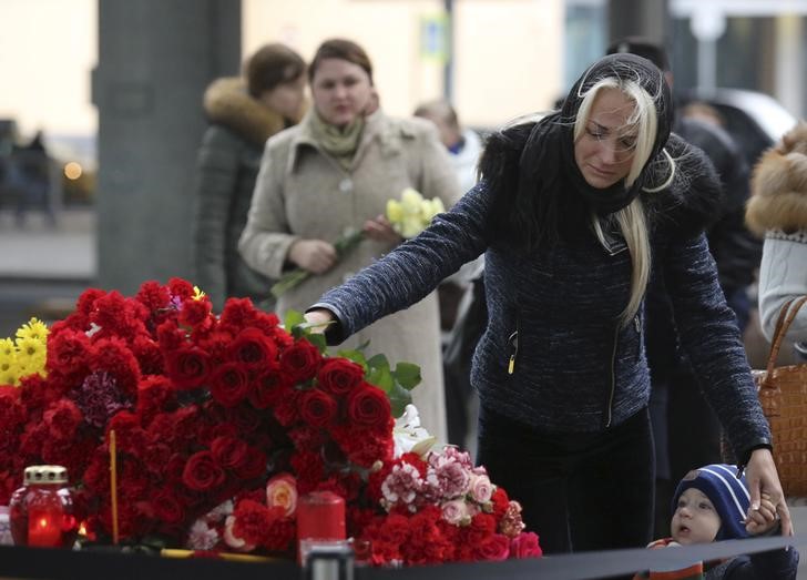 © Reuters. Woman lays flowers on makeshift memorial for victims of Russian airliner which crashed in Egypt outside Pulkovo airport in St. Petersburg