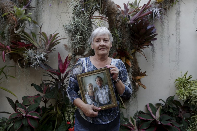 © Reuters. Josefa de Gonzalez poses for a picture while holding a portrait of herself and her late husband Rodolfo Gonzalez at her house in Caracas