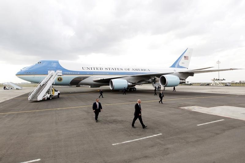 © Reuters. U.S. Secret Service agents walk around Air Force One as it waits to take off to take U.S. President Obama from Kenya's Jomo Kenyatta International Airport in Nairobi to Ethiopia