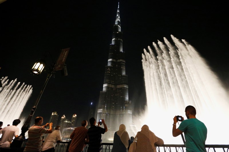 © Reuters. People watch a fountain in front of Burj Khalifa, currently the tallest building in the world, in Dubai