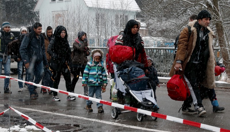 © Reuters. Migrants stay in queue before passing Austrian-German border