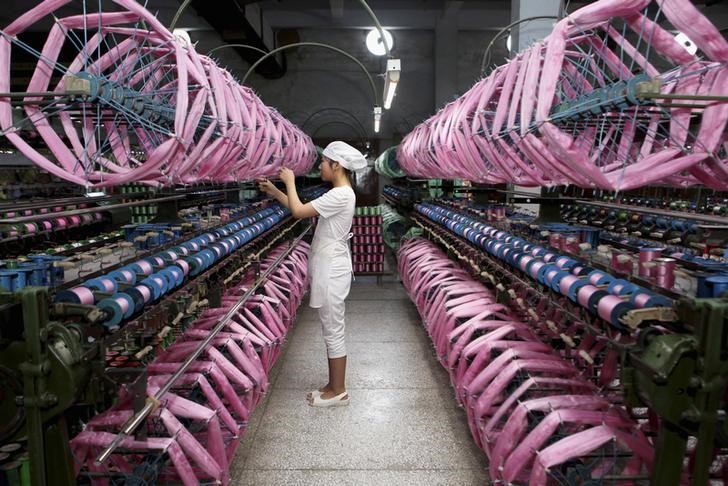 © Reuters. An employee works inside a silk factory in Neijiang
