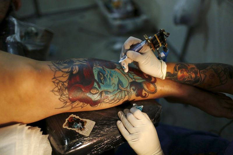 © Reuters. Un tatuatore a lavoro 