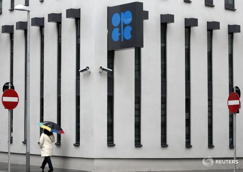 © Reuters. A woman with an umbrella walks past OPEC headquarters during rainfall in Vienna