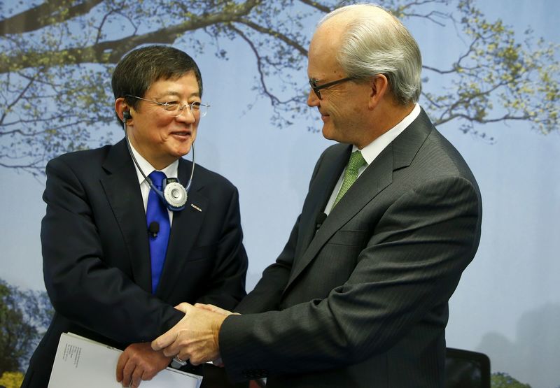 © Reuters. Ren Chairman of China National Chemical Corp shakes hands with Syngenta's President Demare in Basel