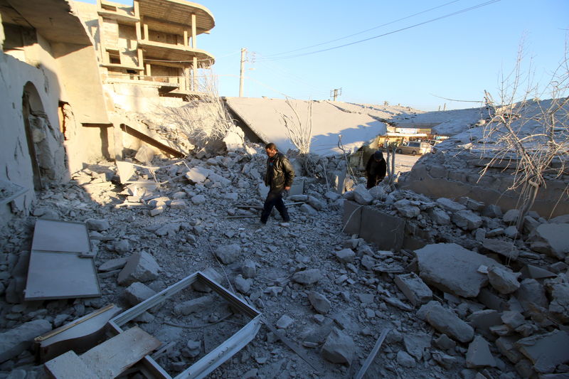 © Reuters. Residents inspect damage after airstrikes by pro-Syrian government forces in Anadan city