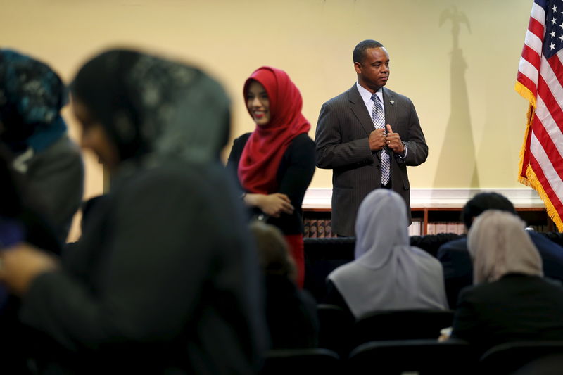 © Reuters. A Secret Service agent keeps watch as people gather in anticipation of remarks by Obama at the Islamic Society of Baltimore mosque in Catonsville, Maryland