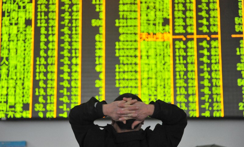 © Reuters. An investor looks at an electronic screen at a brokerage house in Hangzhou