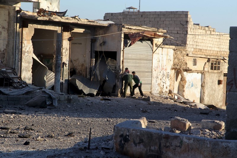 © Reuters. Residents inspect damage after airstrikes by pro-Syrian government forces in Anadan city