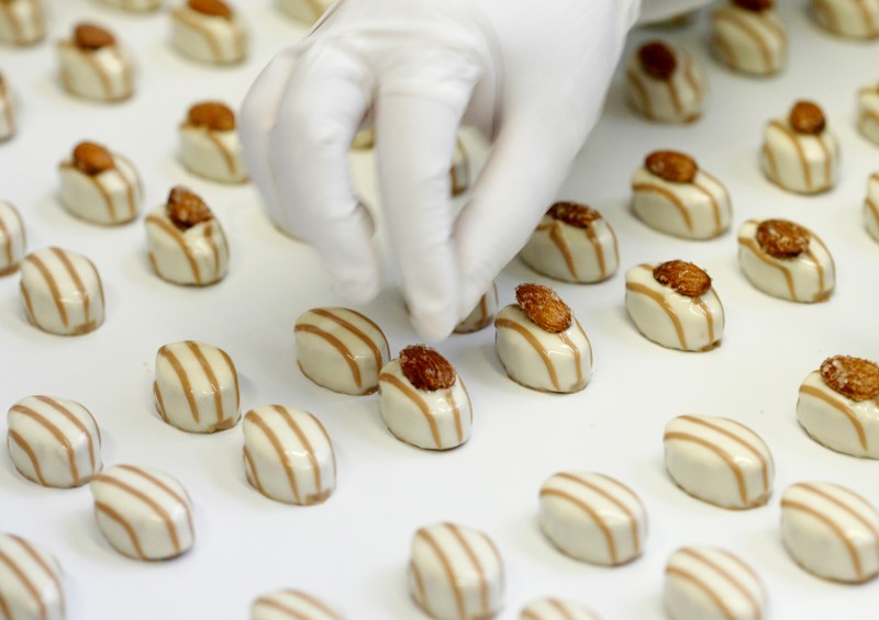 © Reuters. File photo of employee placing almonds on pralines at the plant of Swiss chocolate producer Lindt & Spruengli AG in Kilchberg near Zurich